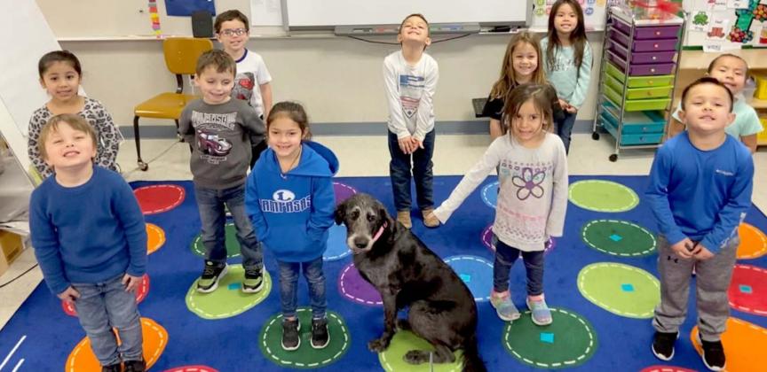 Students from Lexi Simpson’s pre-Kindergarten class pose with Happy, the Hanna Springs Elementary School campus dog. COURTESY PHOTO