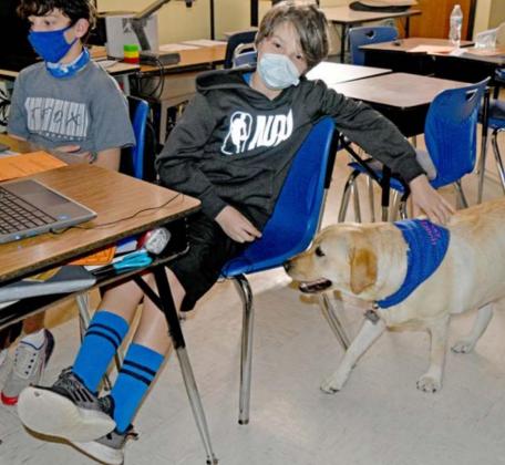 Easton Ybarra, left, and Jayden Havens, right, greet campus dog Honey as she visits their fifth-grade class at Kline Whitis Elementary School. MADELEINE MILLER | DISPATCH RECORD