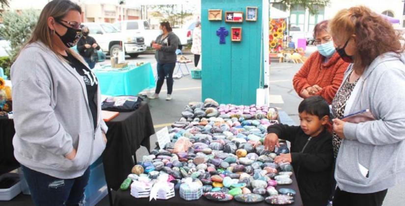 Visitors browse through Christine McDaniel’s painted rocks at her Lampasas Farmers’ Market stand last fall. Market organizer Jerry Hanson plans to continue – and expand – the produce and craft market this year on the downtown square. FILE PHOTO