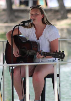 Hometown girls Daelyn Ellis plays her guitar and sings “Those Boots,” written by Lainey Wilson, during music in the park on Wednesday. joycesarah mccabe | dispatch record