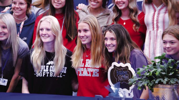 Kali Hunter, left, Bre Quarles and Nyla Long take a photo with their fellow Lady Badgers after signing thier letters of intent last Wednesday. HUNTER KING | DISPATCH RECORD
