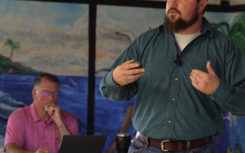 ERICK MITCHELL | DISPATCH RECORD Public Works Director Stephen Sewell, standing, presided over a town hall session last week to offer residents an update on city water conditions. Seated at back is Van Sims, the city’s water/wastewater plant operations manager.