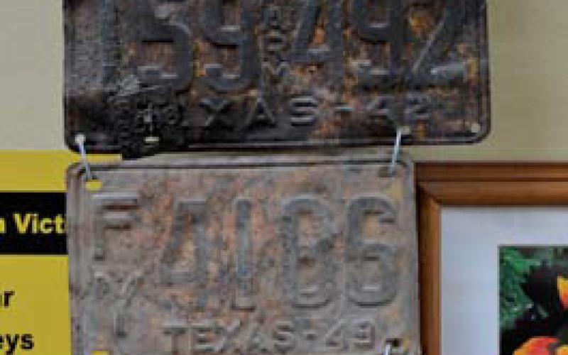 At top is a 1952 Tennessee license plate in the shape of the Volunteer State. Underneath hang Texas plates from 1963, 1942, 1949, 1930 and 1933. erick mitchell | Lampasas Dispatch Record