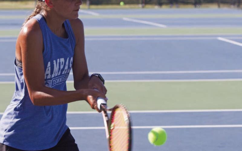 Madelynn White returns a ball on Tuesday in the tennis home opener. She won both her singles match and her doubles match with Tayler Sheard by the same score, 8-1. ERICK MITCHELL | DISPATCH RECORD