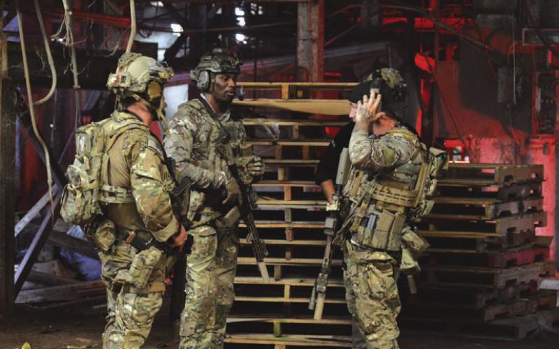 Actors in tactical gear wait to start filming a shootout scene at Brown Feed Store on Friday afternoon. ERICK MITCHELL | DISPATCH RECORD
