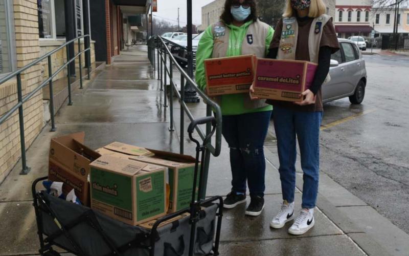 Maggie Ochsner, left, and Charlotte Carmack, members of Lampasas Girl Scout Unit 712, prepare to sell cookies to businesses on the courthouse square on the first day of their selling season. MADELEINE MILLER | DISPATCH RECORD