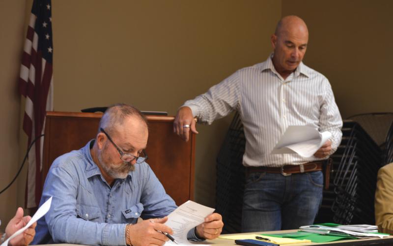 At left, Saratoga UWCD Board President Paul Cline reviews his notes as Director Stan Wilson discusses a change to the district’s fees for non-exempt wells. ERICK MITCHELL | DISPATCH RECORD