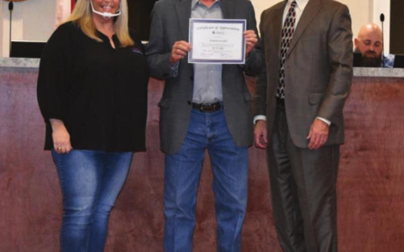 Municipal Judge Robert Gradel, center, receives recognition from Mayor Misti Talbert and City Manager Finley deGraffenried for Gradel’s 25 years of service to the city. Gradel has the longest tenure of the several staff members the City Council recognized Monday for their years of service. MADELEINE MILLER | DISPATCH RECORD