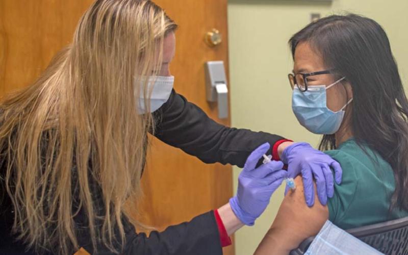 Juana Groat, director of nursing at AdventHealth Rollins Brook, administers a Pfizer COVID-19 vaccine to Michelle Lee. COURTESY PHOTO