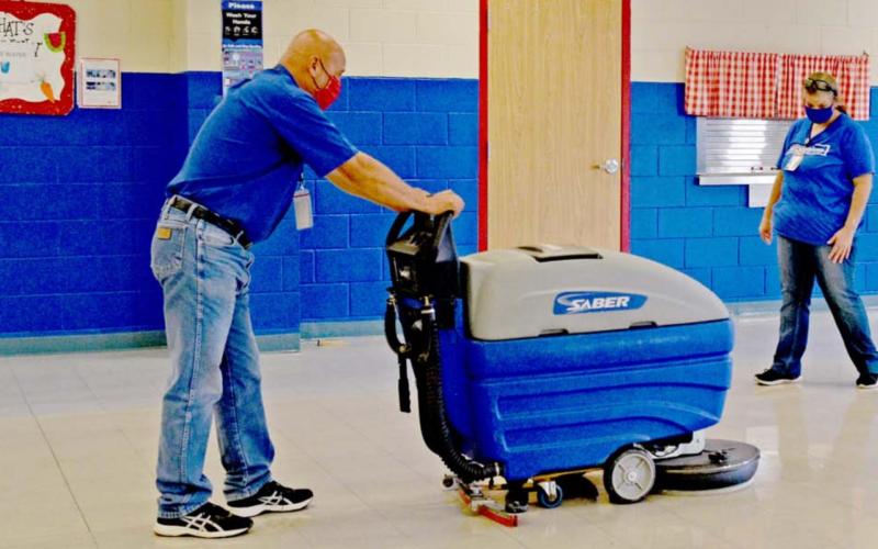 Richard Maceyra Sr., Lampasas Independent School District custodial supervisor, and Sylvania West, morning shift custodian at Hanna Springs Elementary School, clean the school’s cafeteria floor at day’s end. MADELEINE MILLER | DISPATCH RECORD
