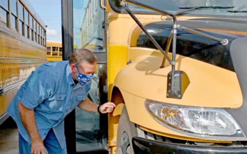 Bus driver John Johnston inspects his bus before beginning the afternoon route. MADELEINE MILLER | DISPATCH RECORD