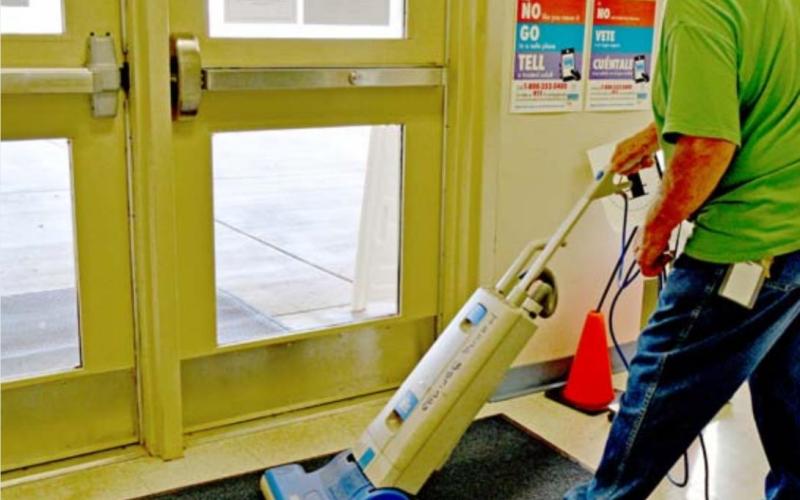 Raymond Valles, a floor technician at Hanna Springs Elementary School, vacuums the school’s vestibule floor shortly before the end of the school day. MADELEINE MILLER | DISPATCH RECORD