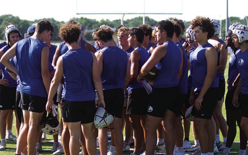 HUNTER KING | DISPATCH RECORD The Badgers huddle following the end of 7-on-7 against the Hornets.