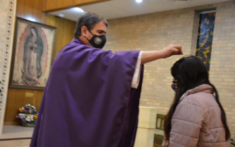 The Rev. Paul Hudson, priest of St. Mary Catholic Church in Lampasas, sprinkles ashes on Jessenia Villegas’ head during an Ash Wednesday evening Mass. The imposition of ashes this year was by sprinkling – rather than imprinting on the forehead – because of COVID-19 precautions. DAVID LOWE | DISPATCH RECORD