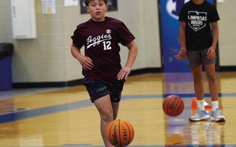 Ayson Nuckles dribbles the ball during youth basketball camp last Tuesday. HUNTER KING | DISPATCH RECORD