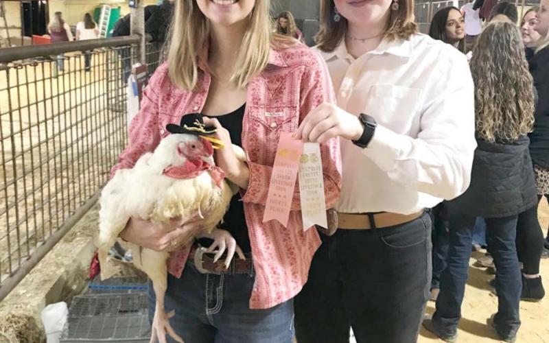 Emma Jones, left, holds a broiler she raised and presented at the Lampasas County Youth Livestock Show. FFA awarded Jones $1,000 for her project of raising nearly 30 chickens in her garage. COURTESY PHOTO