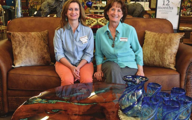 Rustler’s Junction Store Manager Jennifer Chancey, left, and co-owner Carol Chancey pose by a couch upholstered in Texas and a table made in Lampasas County. MADELEINE MILLER | DISPATCH RECORD
