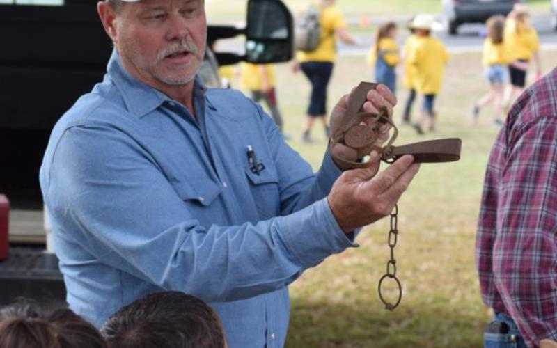 Patrick Flanigan, a wildlife damage management specialist, shows students how a traditional leg trap is set when the USDA Wildlife Service is called in to manage a predator population. ALEXANDRIA RANDOLPH | DISPATCH RECORD