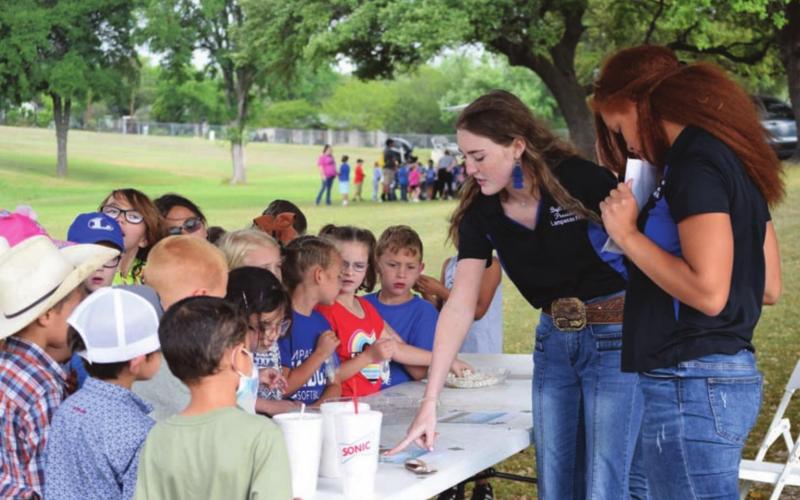 Bryli Wilson, Lampasas County FFA president, in center, and Julian Dwamena, FFA vice president, at right, teach students about the life cycle of a plant with the help of Abriana Flores, FFA reporter (not pictured). Students were encouraged to plant a bean and watch it sprout. ALEXANDRIA RANDOLPH | DISPATCH RECORD