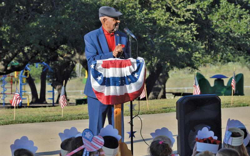 The retired Air Force Chief Master Sgt. Sherman Harper Jr. addresses Taylor Creek Elementary School students on the 24th anniversary of the Sept. 11 terrorist attacks. He also explained the meaning of the colors used in the U.S. flag and encouraged students to honor and respect it. erick mitchell | dispatch record
