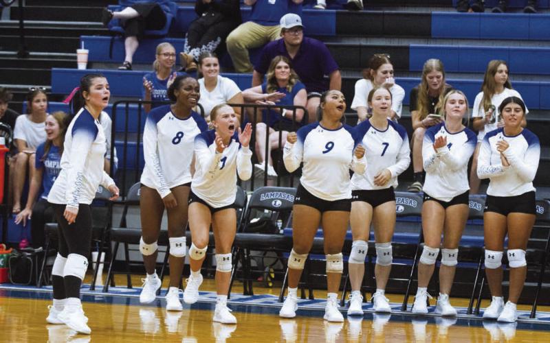 The Lady Badger volleyball bench was on their feet to help push teammates over the line to victory during Tuesday’s opening game against Manor New Tech. ERICK MITCHELL | DISPATCH RECORD
