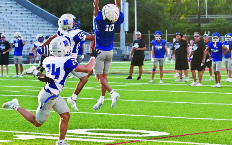 Edwin Gonzalez leaps to make a grab during Thursday’s scrimmage as the Badger coaching staff looks on. ERICK MITCHELL | DISPATCH RECORD