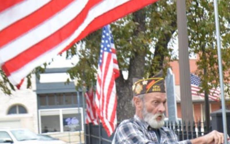 VFW Post 8539 past commander Bob Stewart, who served the United States as a medic during the Vietnam War, posts an American flag outside the county courthouse Monday morning to prepare for Veterans Day. DAVID LOWE | DISPATCH RECORD
