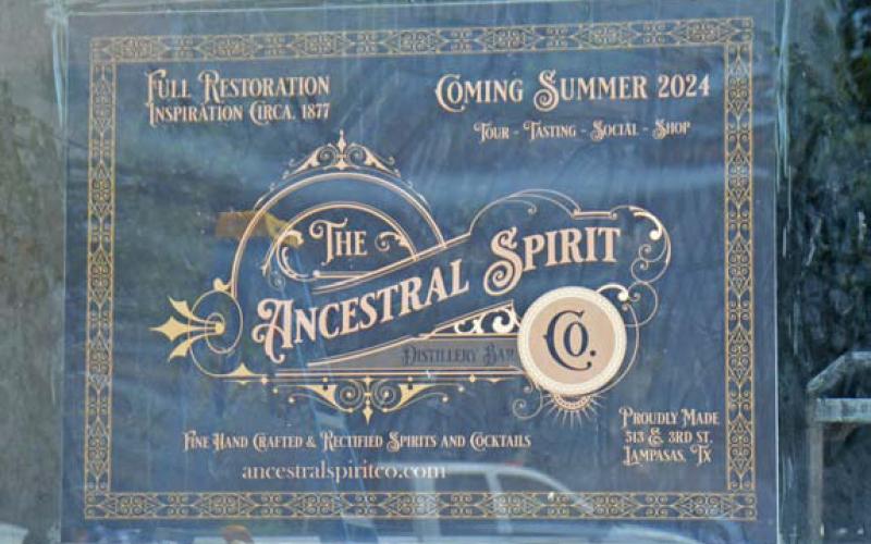 A sign in the window at 513 E. Third St. displays The Ancestral Spirit Co. logo. Owners of the distillery bar anticipate their restoration of the 1870s-era building will be complete by the end of the year. ALEXANDRIA RANDOLPH| DISPATCH RECORD