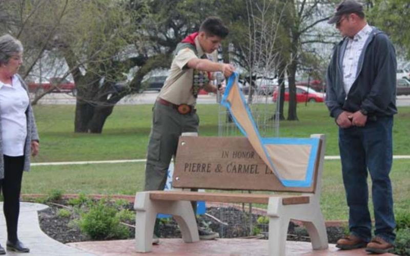 During the dedication of his Eagle Scout project, John T. Saucedo reveals the engraving on a bench he dedicated to Carmel and Pierre LeBlanc – left and right. CHRIS YBARRA | DISPATCH RECORD