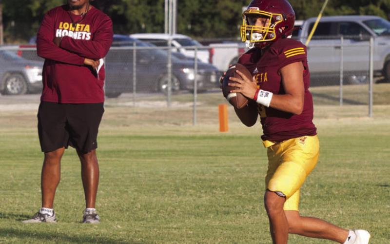 Lometa’s Jose Carbajal rolls out of the pocket as head coach Terrence Wadley observes during Thursday’s home scrimmage against Menard and May. ERICK MITCHELL | DISPATCH RECORD