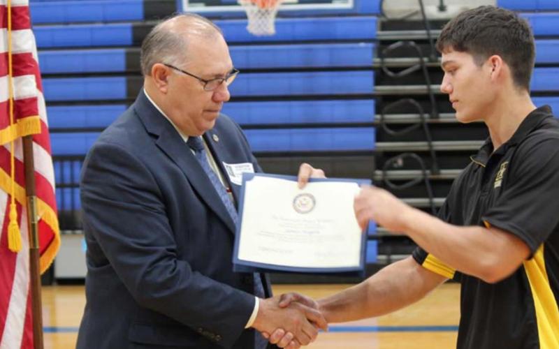 Donald Nicholas hands Lampasas High School senior James Hogan a certificate of congratulations on behalf of Congressman Roger Williams of the 25th District of Texas. CHRIS YBARRA | DISPATCH RECORD