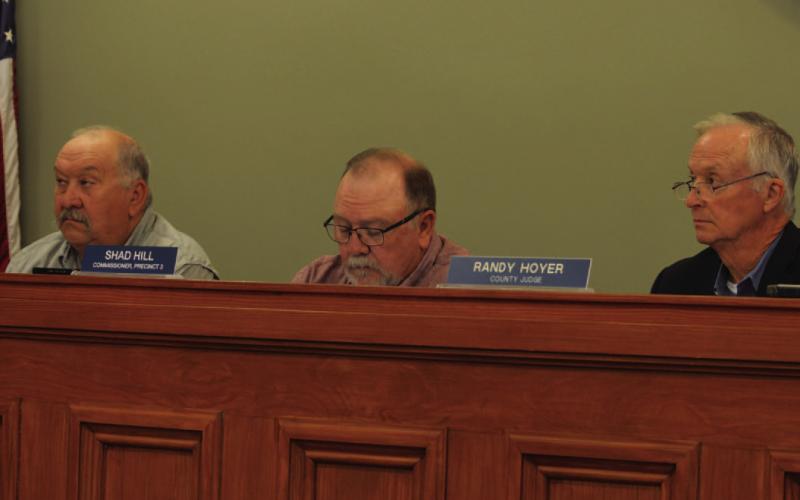Commissioners Court members Mark Rainwater, left, Shad Hill and County Judge Randy Hoyer listen to testimony provided at Monday’s meeting. After hearing concerns from citizens about the proposed 765-kV transmission line that is projected to cross the county, commissioners directed Hoyer to file a protect with the Public Utility Commission. ERICK MITCHELL | DISPATCH RECORD