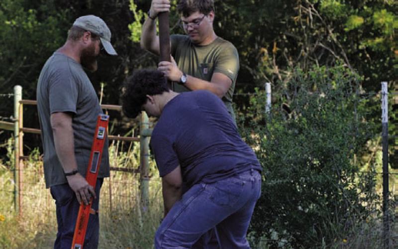 Brennen Barber helps install a 32-foot pole into the ground at Kempner’s Sylvia Tucker Memorial Park on Friday morning. Barber installed two poles for his bat-box project, with each pole able to hold two boxes. ERICK MITCHELL | DISPATCH RECORD