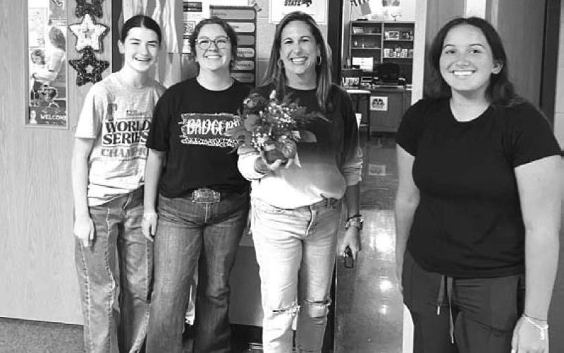 COURTESY PHOTO From left are Kellyn Ramsour, Michaela White, LHS staff member Shea Moyer and Natalie Gresko delivering flowers to those who have signed up for Flower of the Month.