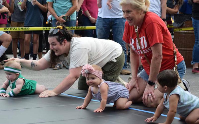 Families from across the county bring their crawlers and toddlers to participate in the Diaper Derby, held on the Lampasas courthouse square. One parent often is stationed at the starting line, while another family member awaits at the finish, coaxing the child across the mat. FILE PHOTO