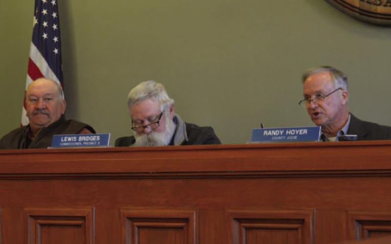 County commissioners Mark Rainwater, at left, and Lewis Bridges listen as County Judge Randy Hoyer asks questions during Monday’s meeting. ERICK MITCHELL | DISPATCH RECORD