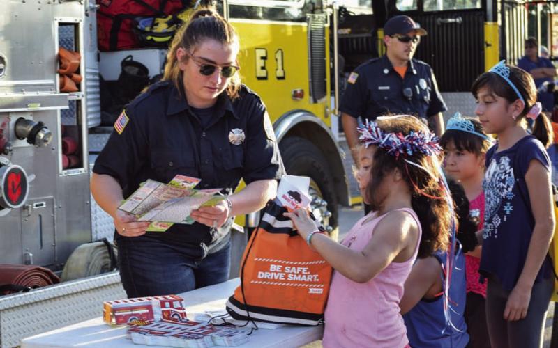 After having to cancel the local observation of National Night Out last year, law enforcement agencies and officials will stage the community engagement event again this year. Booths with giveaways will be set up, as is pictured here, and food and activities will be offered. FILE PHOTO