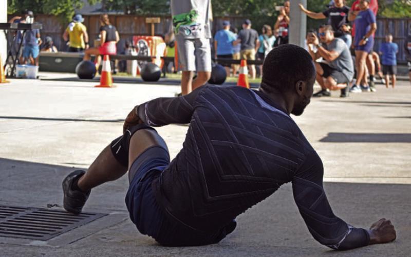 An athlete stretches in preparation for a competition outside of Houston. The assumption that daily exercise is the only requirement for an athlete negates the invisible percentage of work and effort such a lifestyle requires, including nutrition, programming, routine and rest. ALEXANDRIA RANDOLPH | DISPATCH RECORD