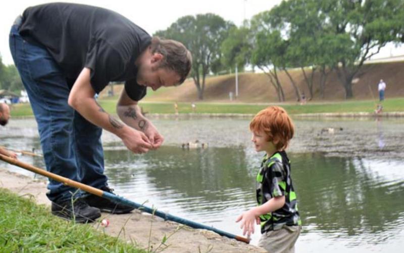 Daniel Chapman prepares a cane pole for his son, Rory Chapman, 7, during the 2021 Spring Ho Festival fishing derby at W.M. Brook Park. file photo