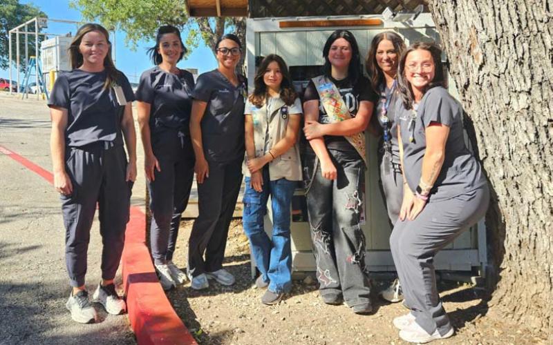 COURTESY PHOTO Standing by the food pantry at 101 E. First St. are, from left, Kaitlin Collins, Jill Sellers, Sarah Rivera, Kenzie Woodfin, Belle Wharton, Brandi Watkins and Miranda Boone.