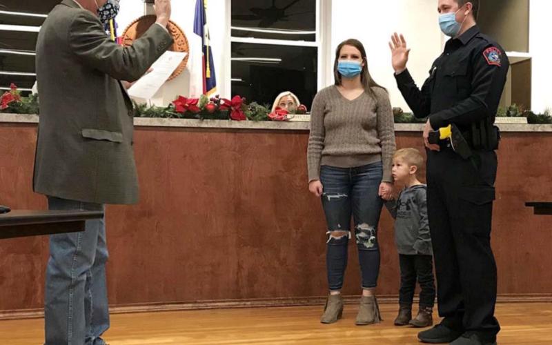 During a Lampasas City Council meeting last week, Municipal Judge Robert Gradel swears in Dylan Boivin -- accompanied by his wife and son -- as a Lampasas Police Department officer. Boivin graduated from Lampasas High School and previously served as a deputy at the Lampasas County Sheriff’s Office. MADELEINE MILLER | DISPATCH RECORD