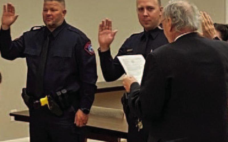 Lampasas Municipal Judge Robert Gradel administers the oath of office to incoming police officers Jacob Loeve and Jeff Phillips. COURTESY PHOTO