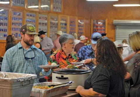 Lampasas County Livestock Association Reverse Raffle attendees stand in line to receive their food during Saturday’s event festivities. erick mitchell | dispatch record