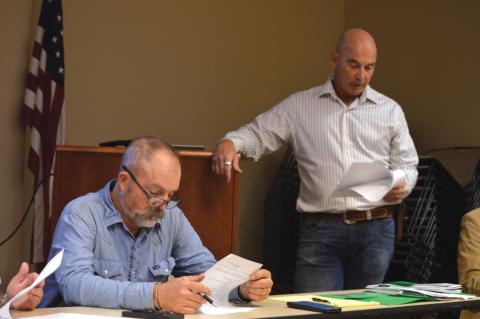 At left, Saratoga UWCD Board President Paul Cline reviews his notes as Director Stan Wilson discusses a change to the district’s fees for non-exempt wells. ERICK MITCHELL | DISPATCH RECORD