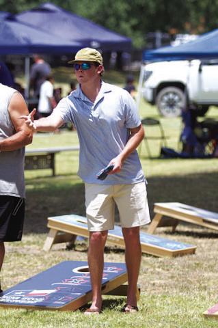 HUNTER KING | DISPATCH RECORD Nate Borchardt tosses a beanbag during the cornhole tournament.