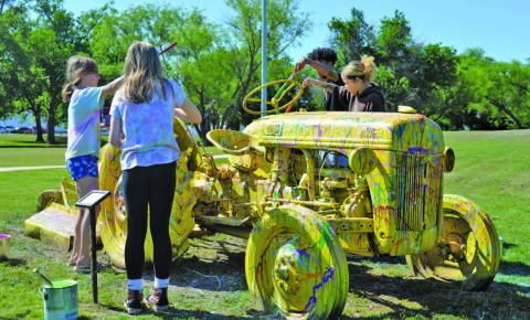 From left to right, Amie Harper, Piper Lindner, Umari Carter and Camryn Brown splatter-paint a tractor during LAFTA’s Arts in the Park event on Saturday. ERICK MITCHELL | DISPATCH RECORD