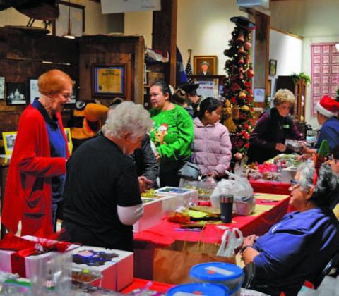 Lampasas County Museum visitors eye the perfect sweet treat during the museum’s annual bake sale during Carol of Lights events on Saturday, ERICK MITCHELL | DISPATCH RECORD