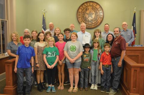 Lampasas County commissioners and County Judge Randy Hoyer (holding a resolution) pose for a photo with area 4-H students and leaders after approval of the proclamation highlighting National 4-H Week that runs Oct. 6-12. erick mitchell | dispatch record