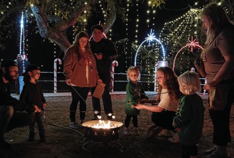 At left, families spend time making s’mores while enjoying the Christmas on the Creek holiday lights along Sulphur Creek. Guests had the opportunity to partake of hot chocolate, cotton candy and s’mores as they walked the pathway of lights and visited Santa’s Christmas village.