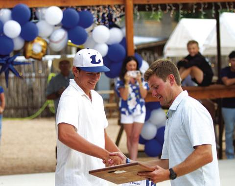 Calvin Phelps, left, receives the Pitcher of the Year award from assistant coach Hadley Berry. HUNTER KING | DISPATCH RECORD